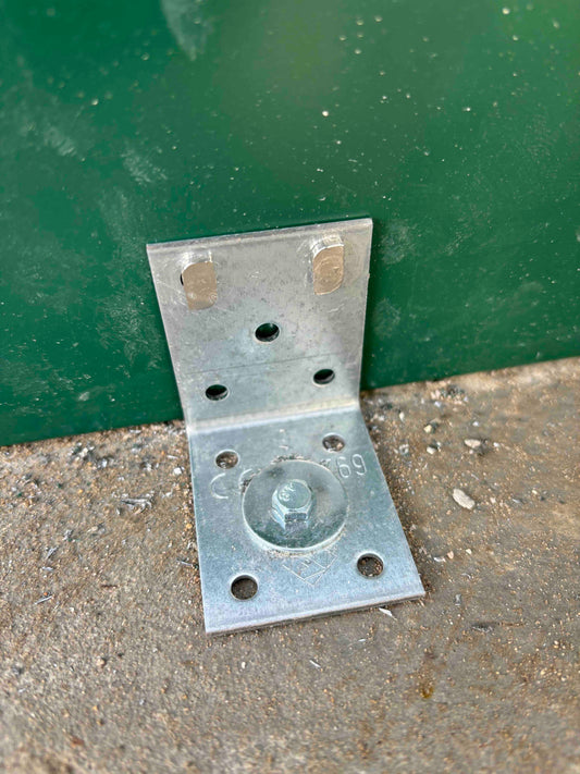 Steel anchor bracket securing greenhouse base to concrete floor