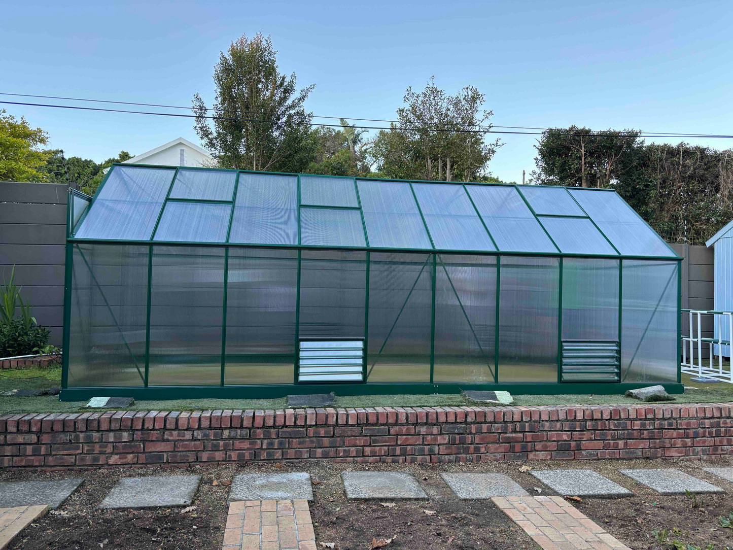 6 meter aluminium-frame greenhouse with UV-protected polycarbonate panels in garden setting