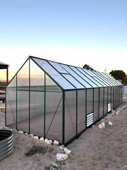 9 meter polycarbonate greenhouse with green aluminium frame on sandy ground outdoors