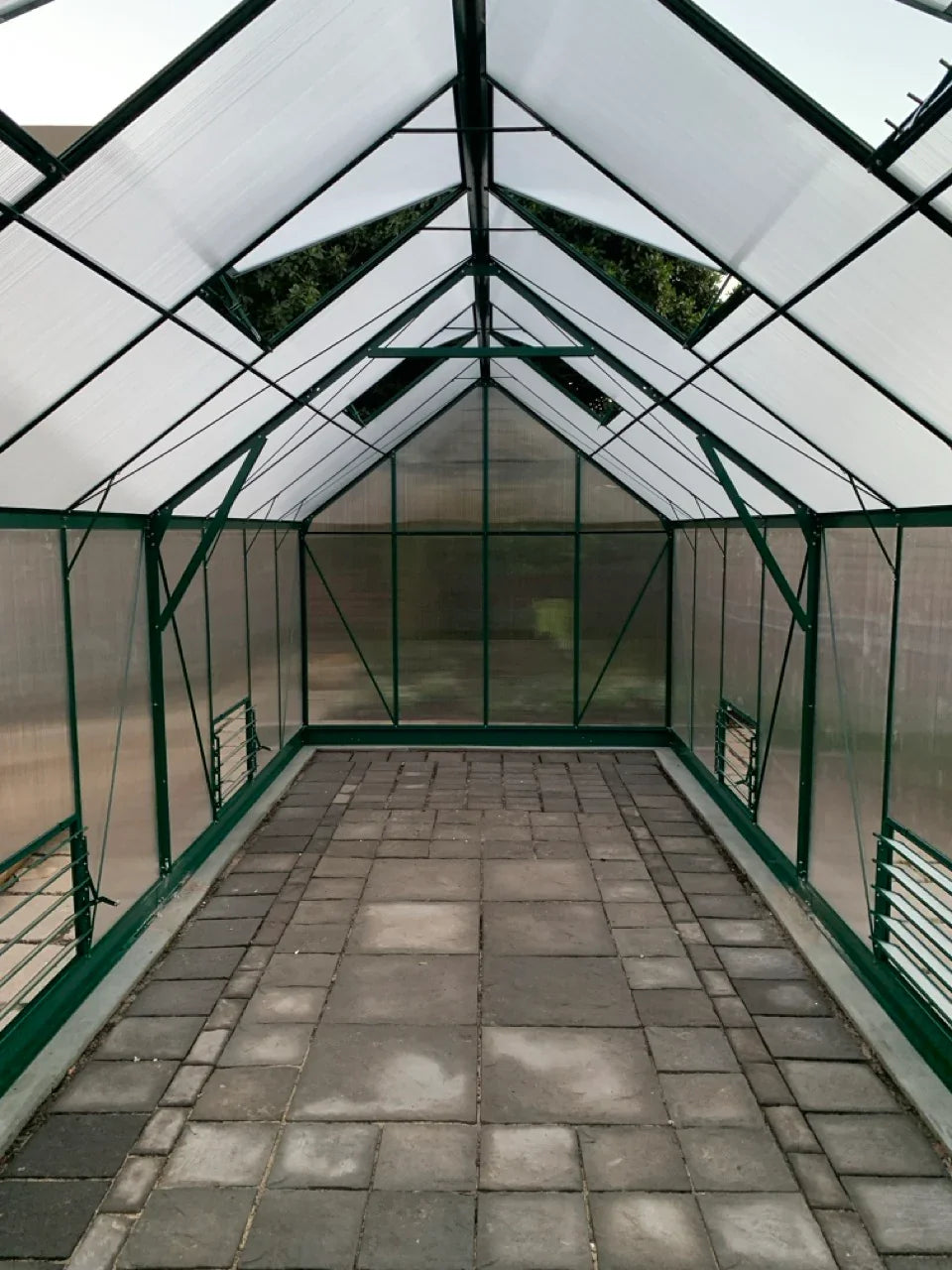 Greenhouse interior with glass panels and a paved floor