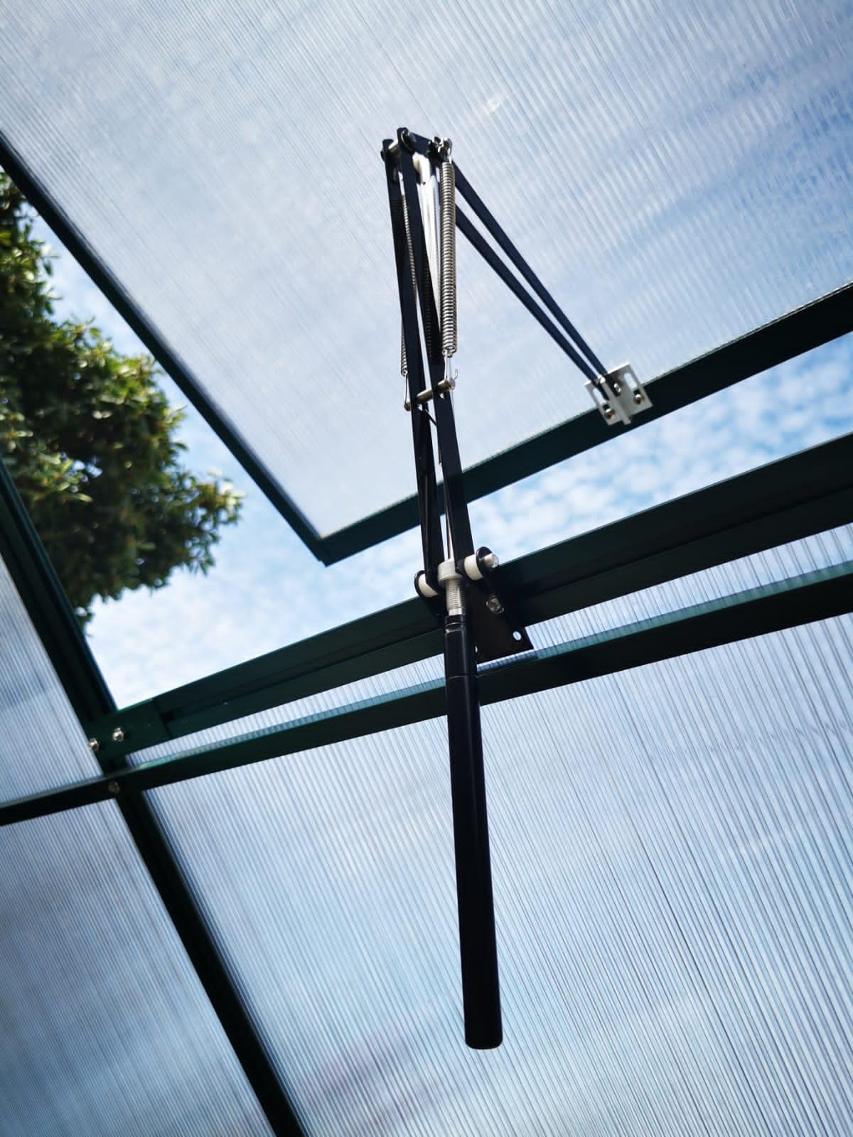 Automatic greenhouse vent opener installed on polycarbonate panel roof